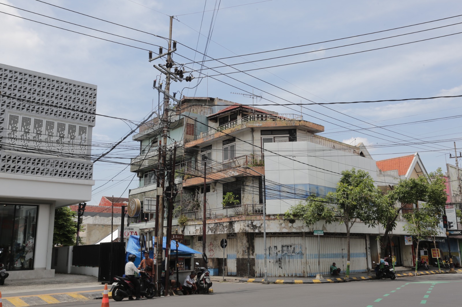 SEMRAWUT: Kabel udara fiber optik milik sejumlah provider internet terpasang ruwet di Jalan Barito, Kota Madiun, dan akan ditertibkan Pemkot Madiun. BAGAS BIMANTARA/RADAR MADIUN