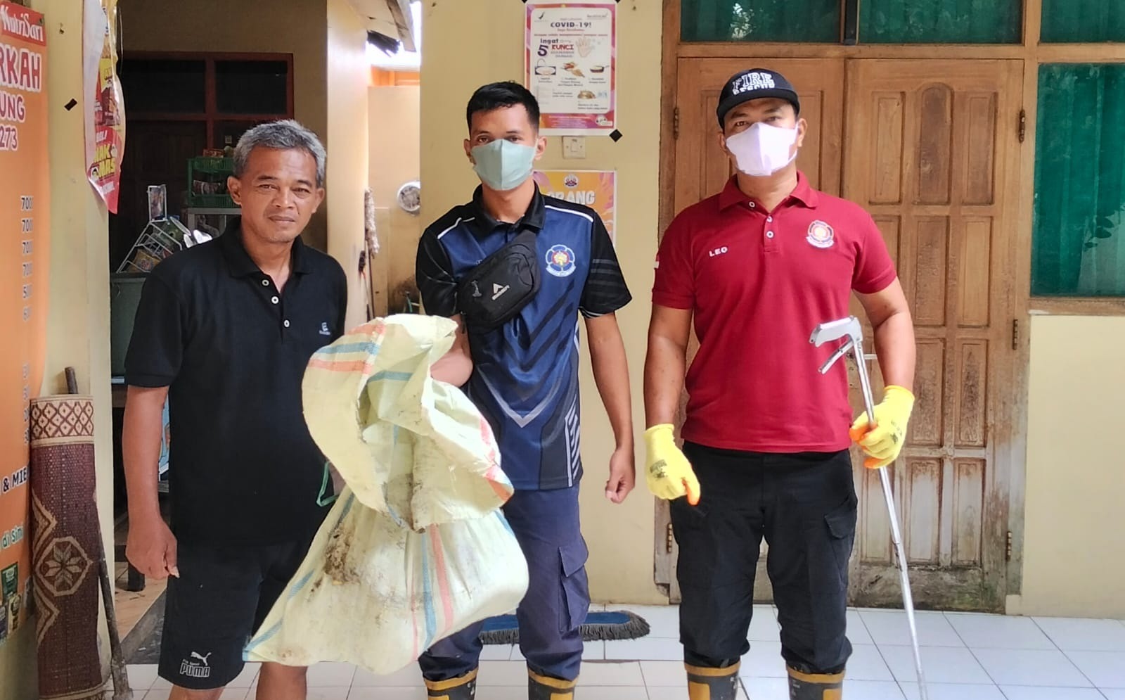 EVAKUASI: Petugas Satpol PP dan Damkar Magetan mengevakuasi ular piton sepanjang tiga meter yang ditemukan di kantin SMAN 2 Magetan. AJI PUTRA/RADAR MAGETAN