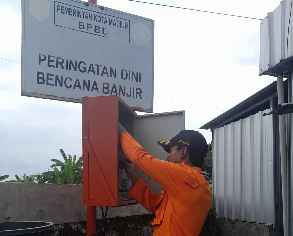 TEKNIS: Petugas BPBD Kota Madiun melakukan pengecekan dan pemeliharaan EWS di Jembatan Bok Malang untuk memastikan peringatan dini banjir tetap berfungsi.