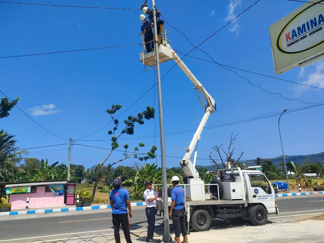 MAINTENANCE: Petugas Dinas Perhubungan Pacitan melakukan perbaikan penerangan jalan umum (PJU) di salah satu ruas jalan kabupaten, Selasa (13/1). NUR CAHYONO/RADAR PACITAN