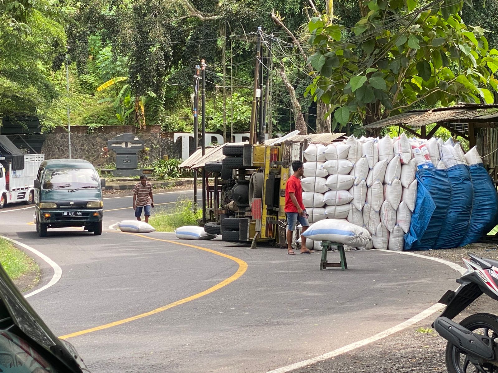LAKA TUNGGAL: Truk bermuatan merang padi terguling dan melintang di jalur Ponorogo&ndash;Trenggalek, Desa Pangkal, Kecamatan Sawoo, Selasa (13/1). SUGENG DWI N/RADAR PONOROGO