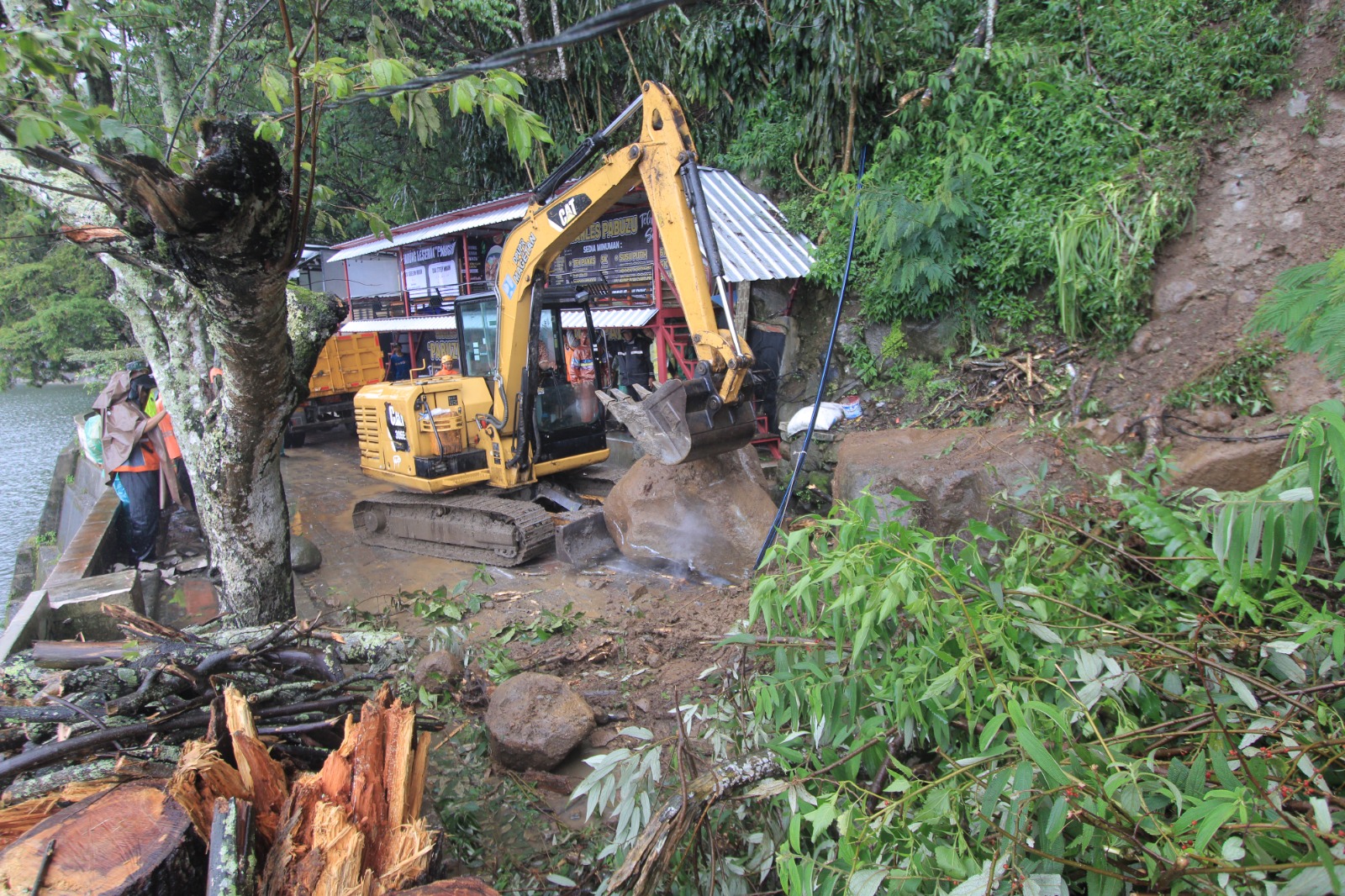 EVAKUASI &ndash; Dinas Pekerjaan Umum dan Penataan Ruang (DPUPR) Magetan mengerahkan alat berat untuk mengevakuasi material longsor di jalan lingkar Telaga Sarangan. AJI PUTRA/RADAR MAGETAN