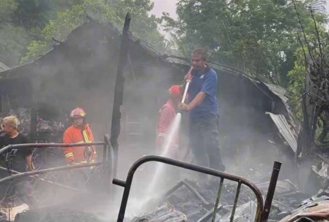 SI JAGO MERAH: Petugas Damkar Pacitan melakukan pendinginan di lokasi kebakaran rumah pengepul rosok di Desa/Kecamatan Punung, Kamis (15/1). FOTO: ISTIMEWA