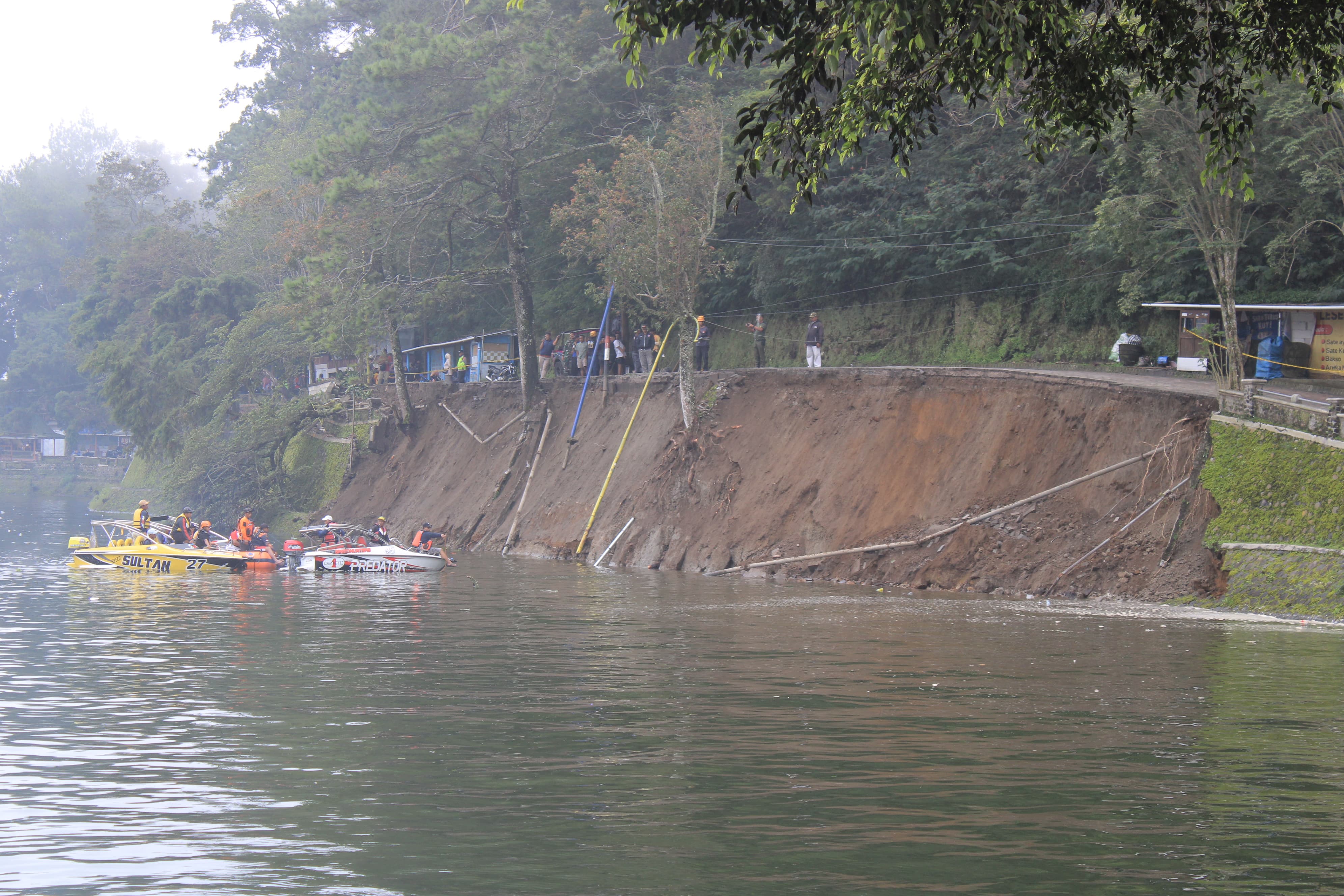 EVAKUASI RAMPUNG: Petugas mengevakuasi sepeda motor wisatawan yang tenggelam di Telaga Sarangan akibat longsor, Sabtu (17/1). AJI PUTRA/RADAR MAGETAN