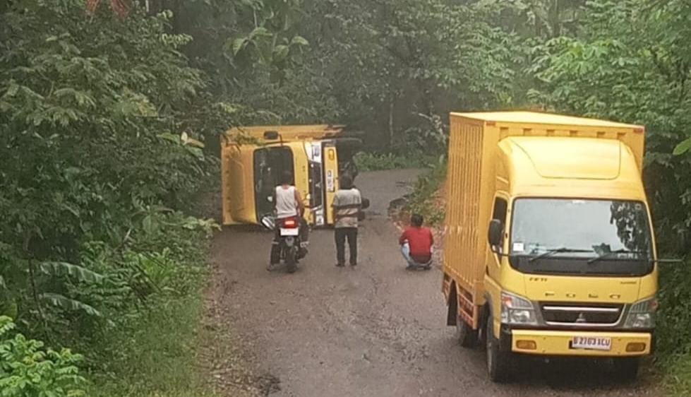 TERGULING: Truk box terguling di tanjakan Jalan Raya Tegalombo&ndash;Tulakan, Pacitan, Minggu (18/1) pagi, diduga akibat kehabisan BBM. FOTO: ISTIMEWA