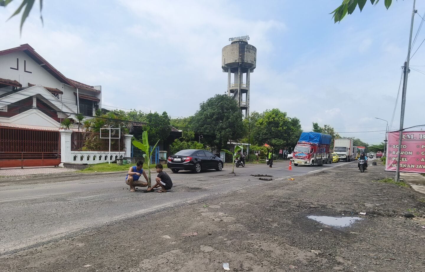 PROTES JALAN RUSAK: Warga menanam pohon pisang di lubang jalan nasional Solo&ndash;Ngawi, Desa Sambirejo, Mantingan, sebagai bentuk kritik terhadap kerusakan jalan. ASEP SYAEFUL/RADAR NGAWI