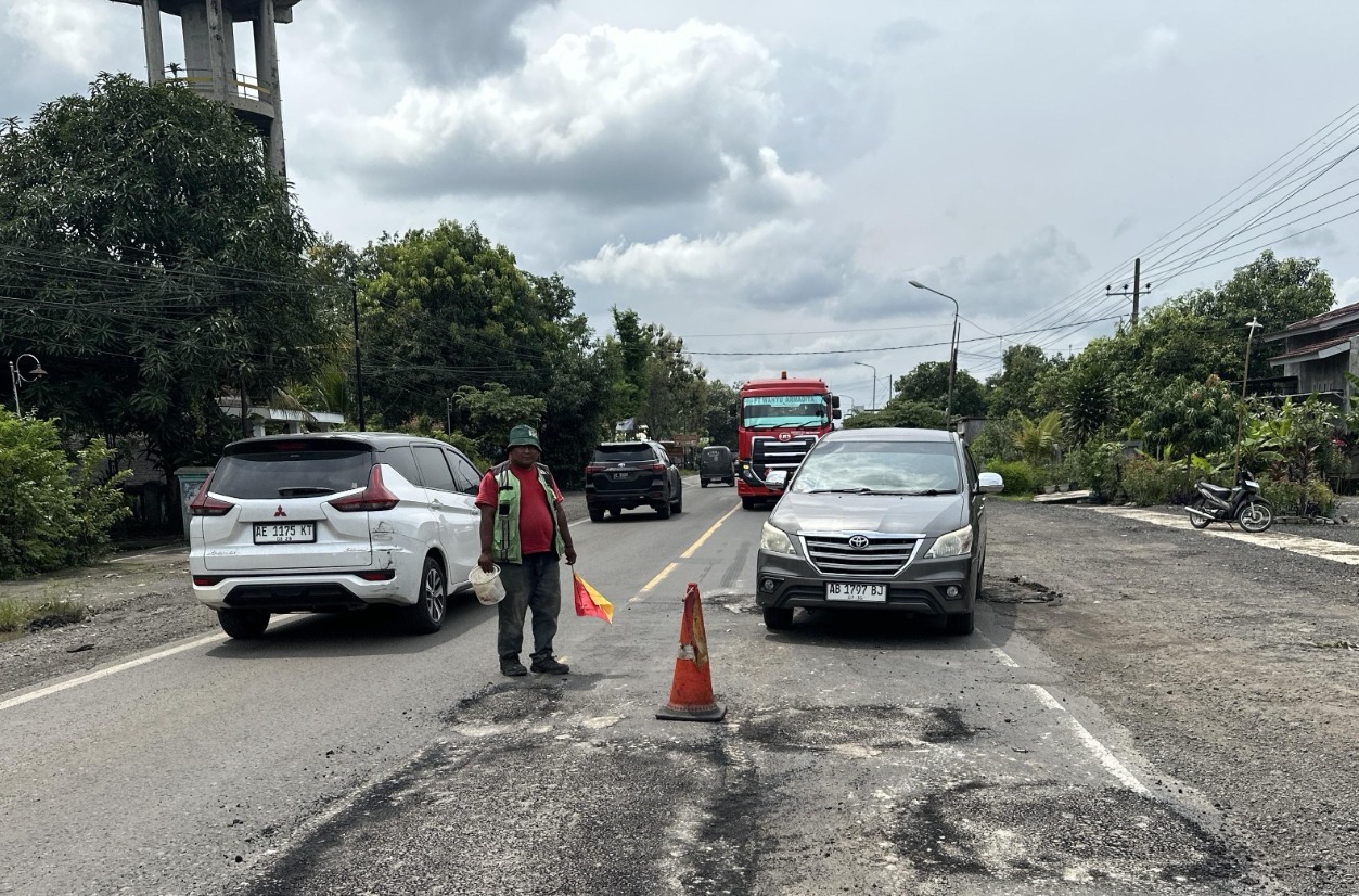 DARURAT: Petugas BBPJN Jawa Timur&ndash;Bali menambal jalan berlubang di ruas Solo&ndash;Ngawi usai aksi tanam pisang oleh warga, Sabtu (17/1). FOTO: ISTIMEWA