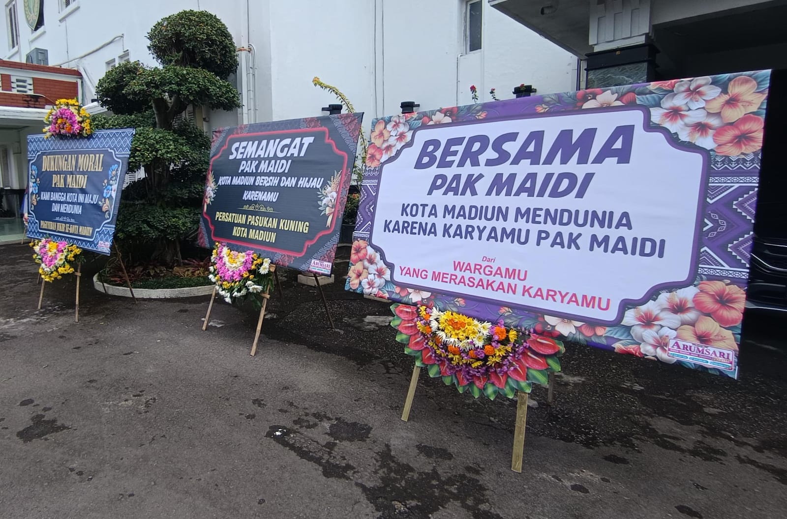 MERASA PEDULI: Karangan bunga berisi dukungan dan simpati dari masyarakat terpasang di depan Balai Kota Madiun, Rabu (21/1). FOTO: ISTIMEWA