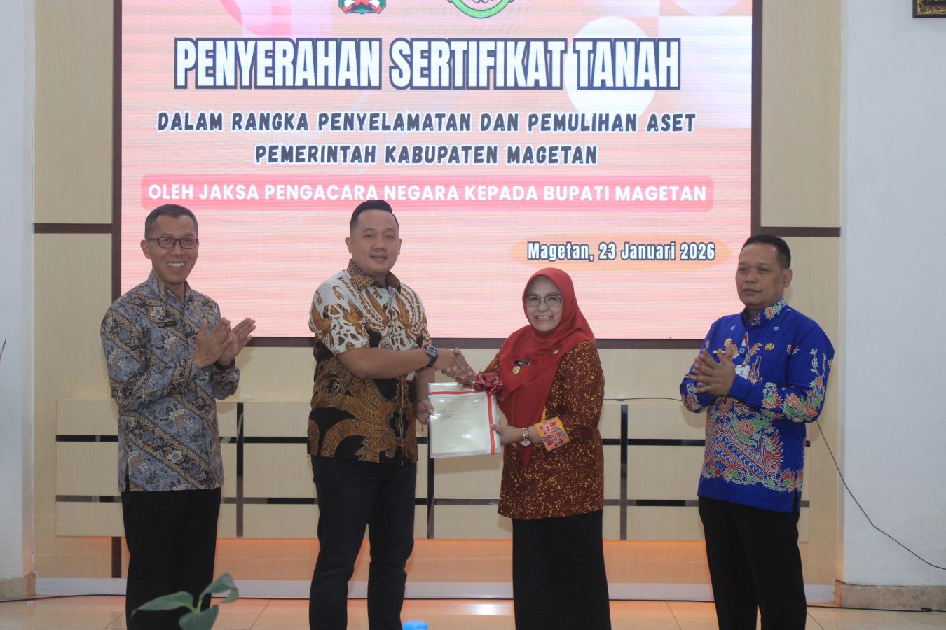 KOLABORASI: Plt Kajari Magetan Farkhan Junaedi secara simbolis menyerahkan sertifikat aset pemkab yang berhasil diselamatkan oleh JPN Kejari Magetan kepada Bupati Nanik Endang Rusminiarti.