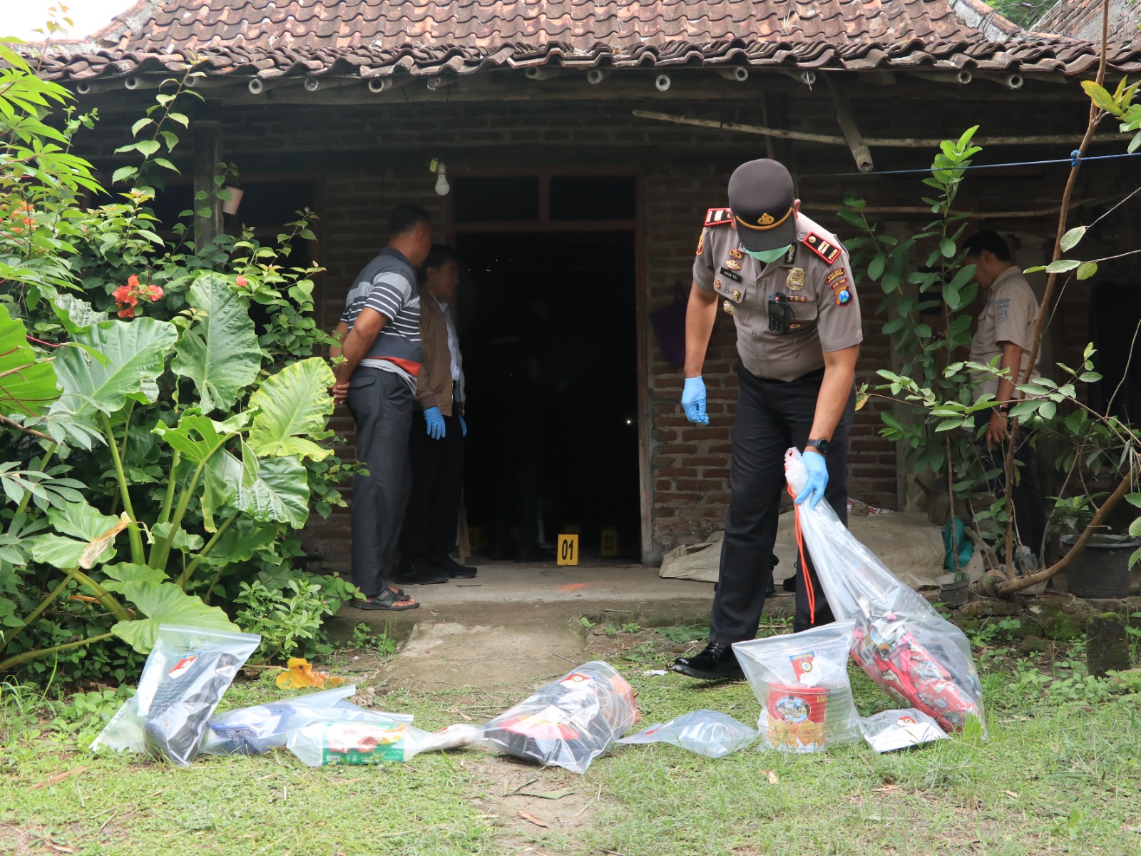 Petugas Satreskrim Polres Ponorogo mengamankan barang bukti dari rumah Nuraini di Desa Golan, Sukorejo, lokasi ditemukannya korban tewas. SUGENG DWI N/RADAR PONOROGO