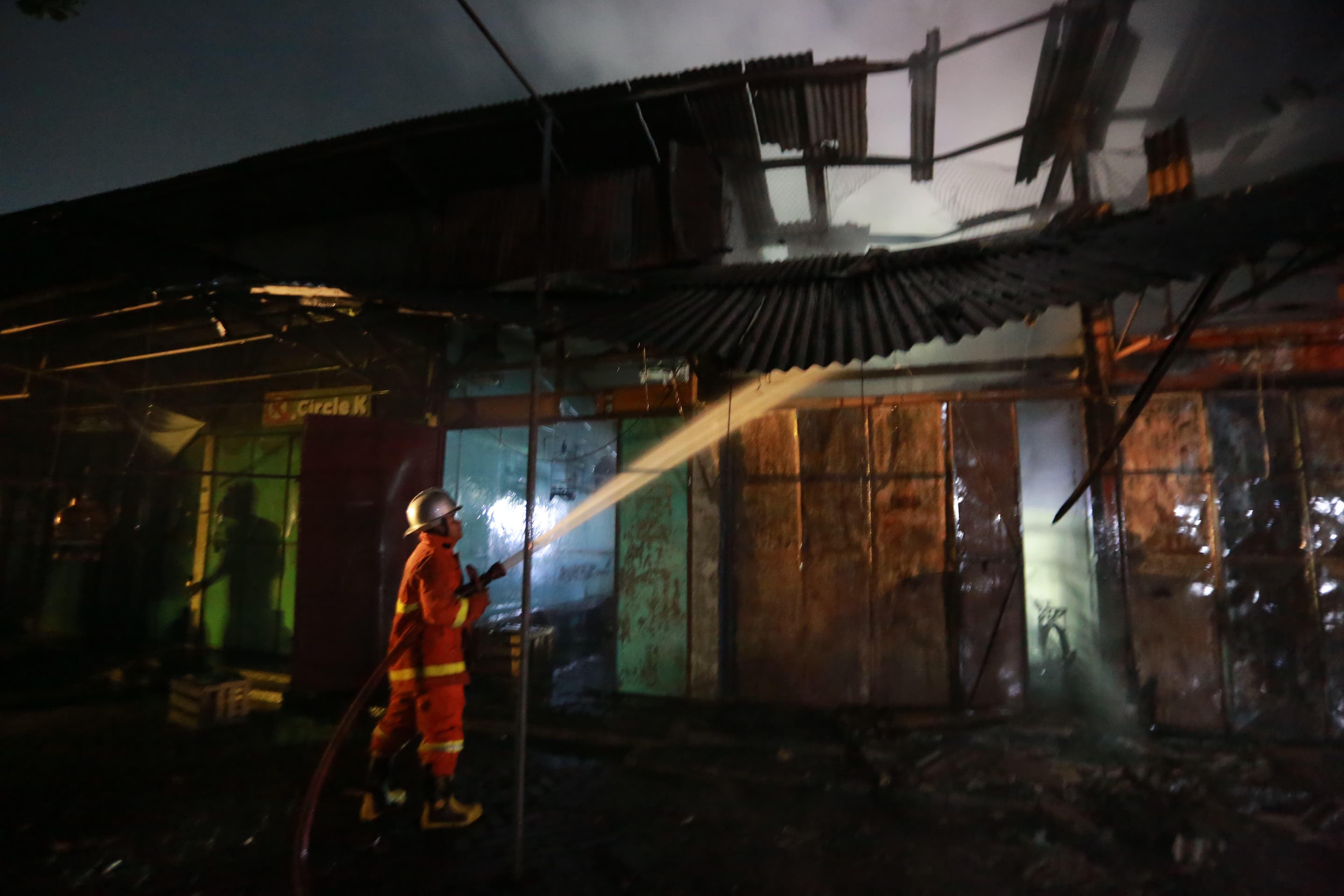 Petugas pemadam kebakaran berjibaku memadamkan api yang melahap kios di Pasar Burung Srijaya, Kartoharjo, Kota Madiun, Senin malam (26/1). BAGAS BIMANTARA/RADAR MADIUN