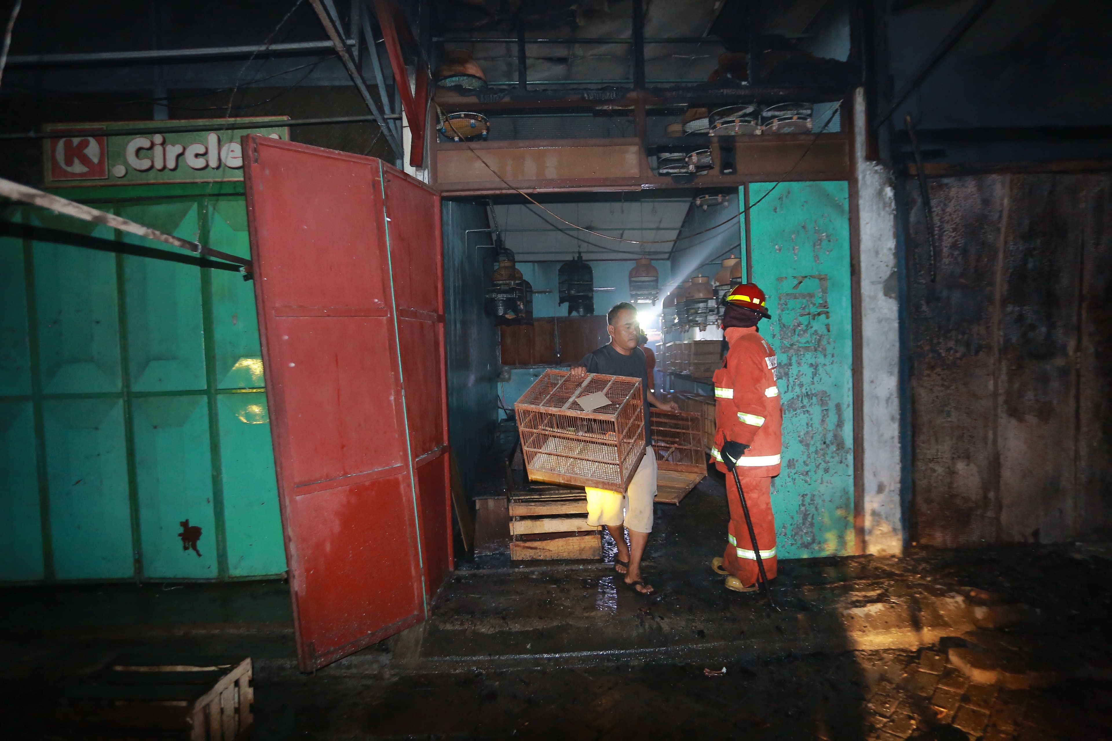 PENYELIDIKAN: Tim Inafis dari Polres Madiun Kota melakukan olah TKP di lokasi kebakaran yang menghanguskan tiga kios di Pasar Burung Srijaya kemarin (27/1).