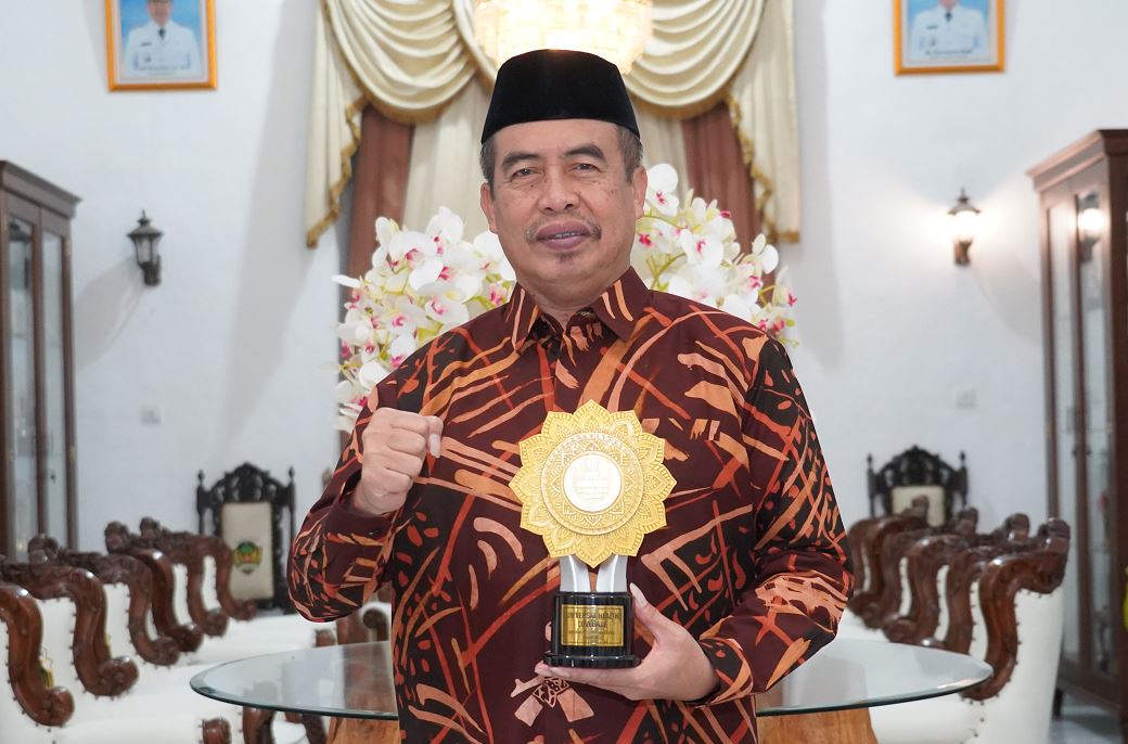 PRATAMA: Bupati Madiun, Hari Wuryanto menunjukan penghargaan UHC Award kategori Pratama yang kembali diraih Pemkab Madiun.