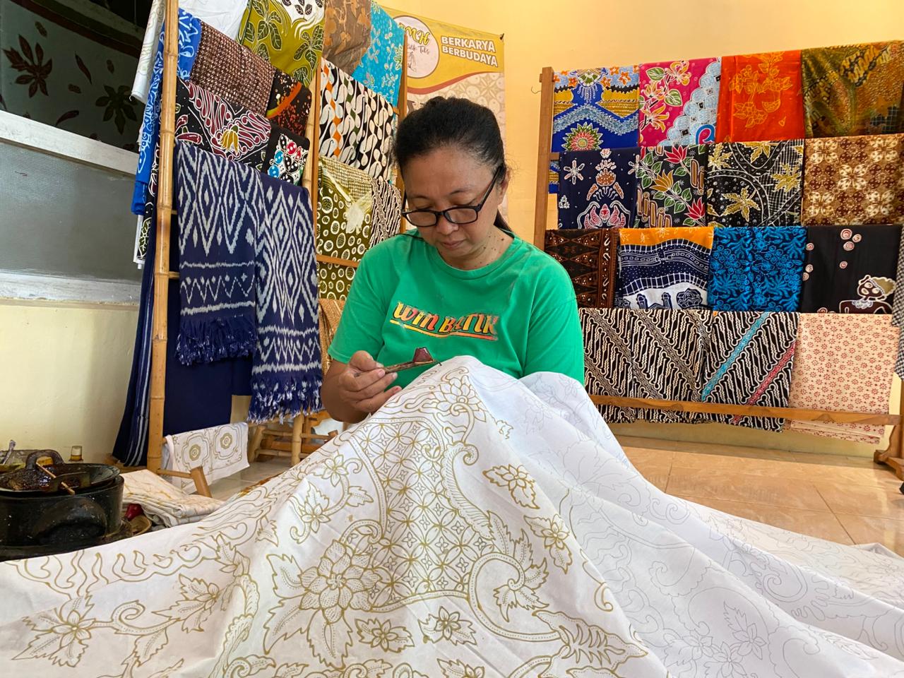 Lilik Widiawati menunjukkan keterampilannya membatik di WMH Batik, Winongo, Madiun&mdash;usaha rumahan yang menembus pasar internasional. ERLITA HERMININGSIH/RADAR MADIUN