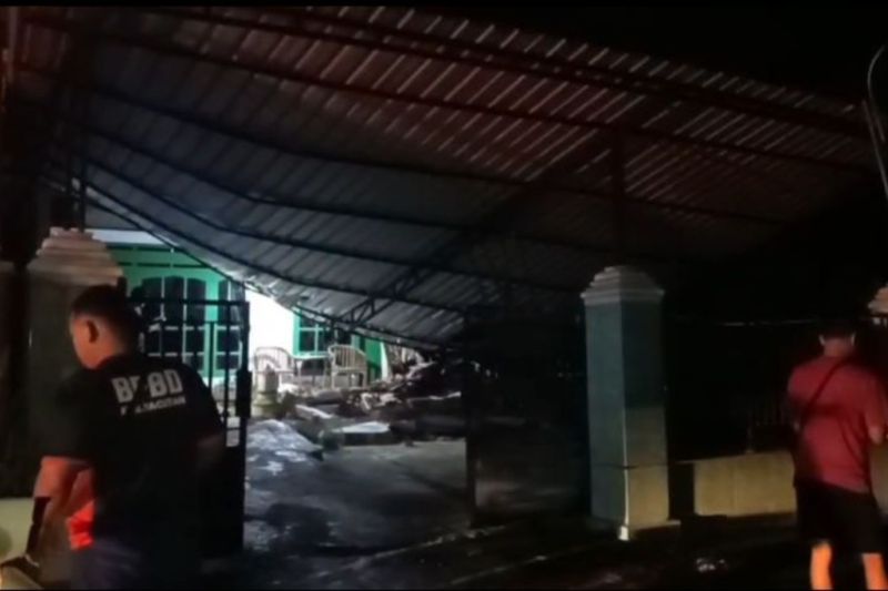 Warga mengamati bangunan rumah yang dilaporkan mengalami kerusakan pascagempa bumi di Pacitan, Jawa Timur, Jumat (6/2).