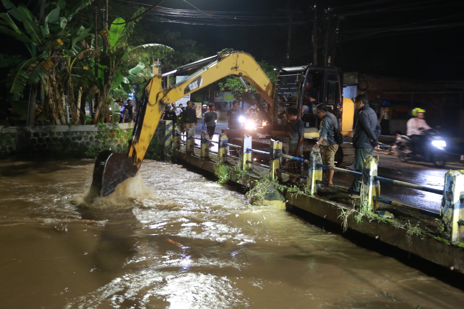 Petugas BPBD bersama DPUPR mengangkat tumpukan sampah plastik dan bambu yang menyumbat aliran Kali Piring di bawah jembatan Bok Malang, Kota Madiun, Jumat (6/2). BAGAS BIMANTARA/RADAR MADIUN
