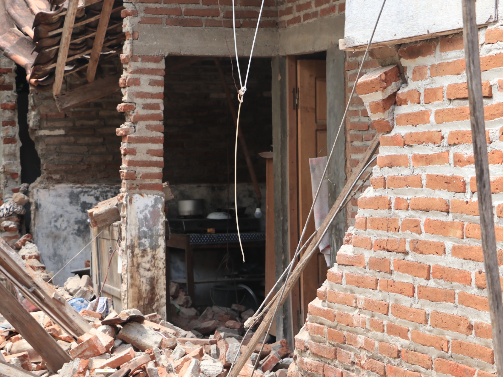 Petugas BPBD Ponorogo melakukan asesmen dan pembersihan puing bangunan di salah satu titik kerusakan rumah warga pascagempa Pacitan, Jumat (6/2). SUGENG DWI N/RADAR PONOROGO