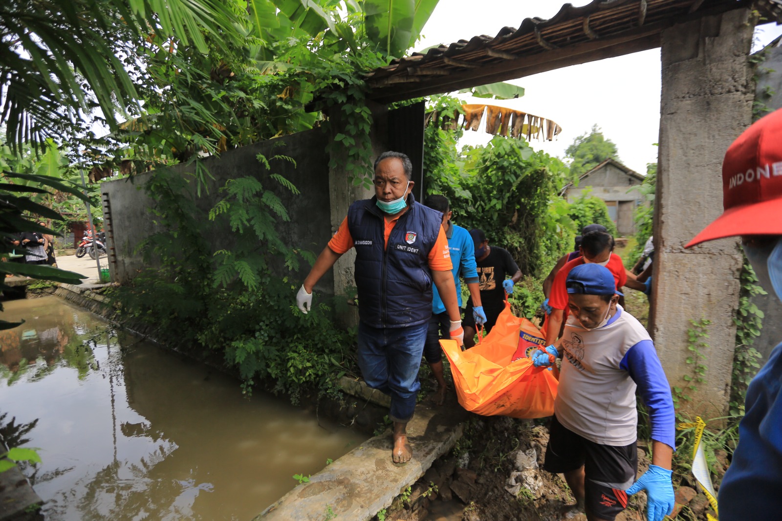 DIBAWA KE RS: Polisi mengevakuasi jasad Bibit dari rumahnya di Desa Grobogan, Kecamatan Jiwan, Kabupaten Madiun, Minggu (8/2). BAGAS BIMANTARA/JAWA POS RADAR MADIUN