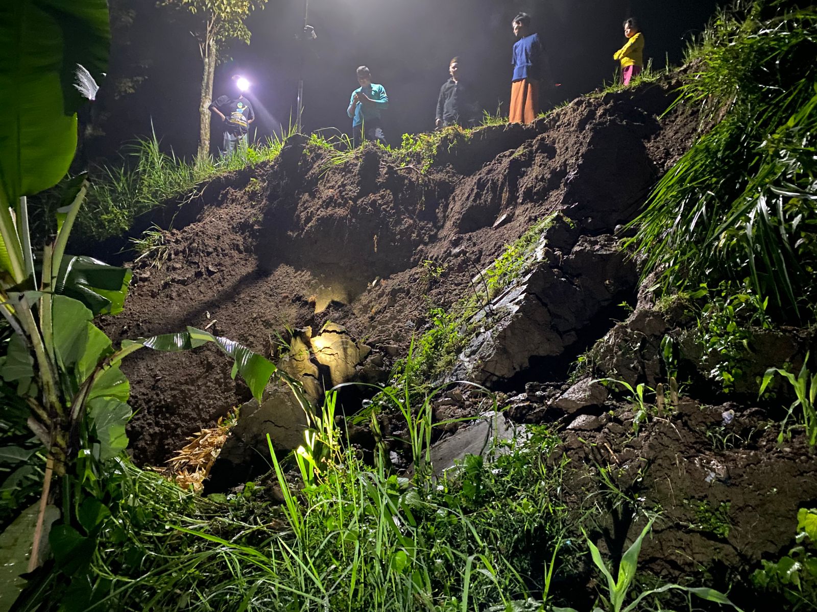 BAHAYA LONGSOR: Tebing longsor di Plangkrongan, Poncol, Magetan, menimpa saluran irigasi dan bahu jalan desa, Minggu (8/2). FOTO: ISTIMEWA