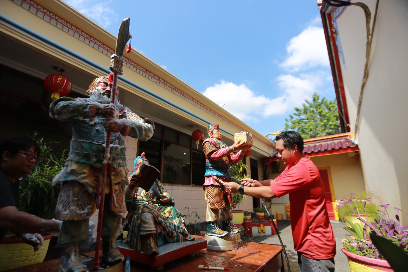 KIMSIN: Sesepuh TITD Hwie Ing Kiong Kota Madiun membersihkan rupang dewa-dewi menggunakan air kembang jelang Imlek, Kamis (12/2). BAGAS BIMANTARA/RADAR MADIUN