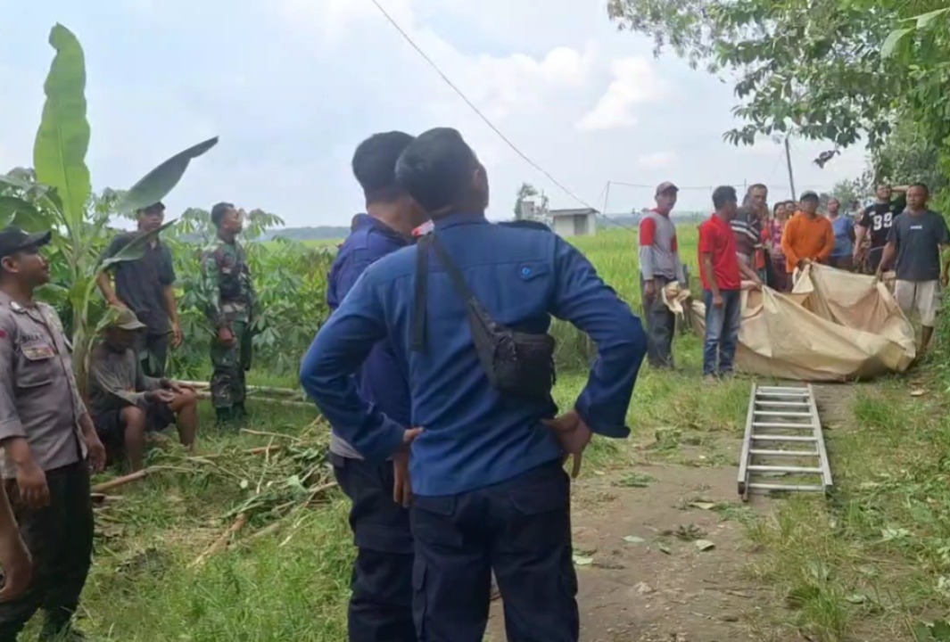 LOKASI KEJADIAN: Warga bersama petugas mengevakuasi jasad Panut yang ditemukan tersangkut di pohon lamtoro setinggi delapan meter.