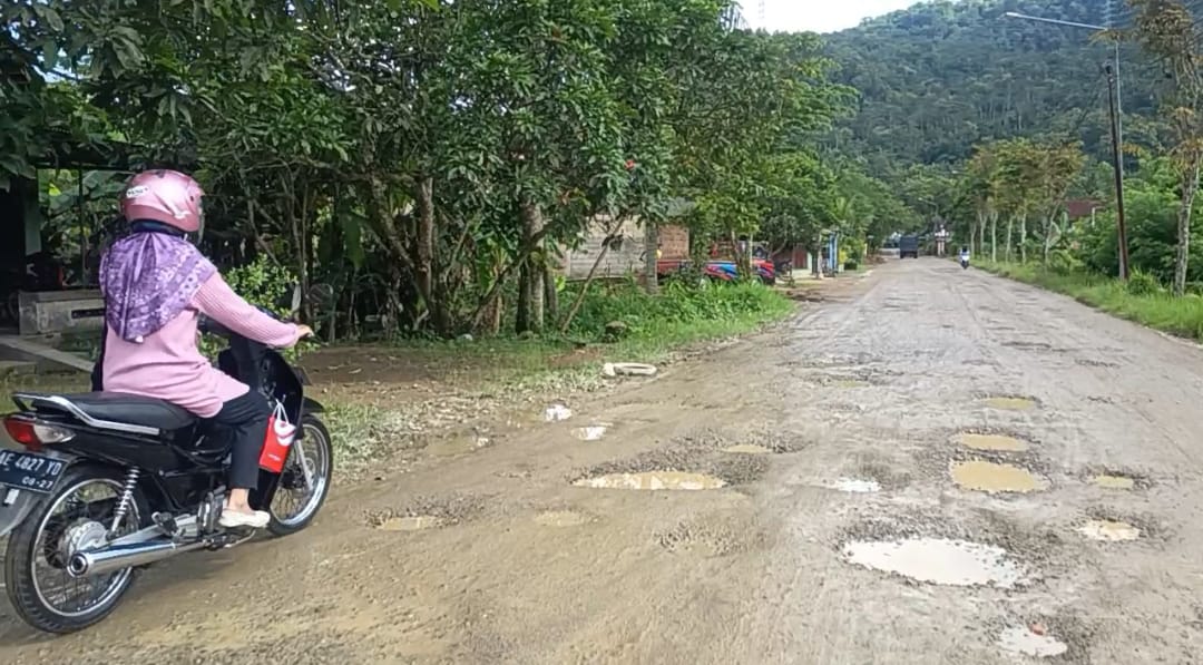 HATI-HATI: Sejumlah pengendara tampak waspada saat melintas di Jalan Mentoro&ndash;Arjosari, Pacitan, yang rusak dan banyak lubang tertutup genangan. NUR CAHYONO/RADAR PACITAN