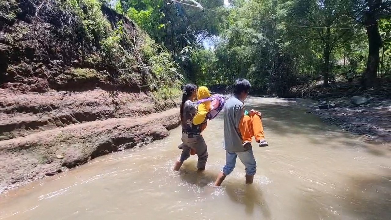 TERISOLIR: Warga Dusun Karangsengon, Desa Sidoharjo, Jambon, terpaksa menyeberangi derasnya arus Sungai Bentul untuk aktivitas setiap hari. SUGENG DWI N/RADAR PONOROGO
