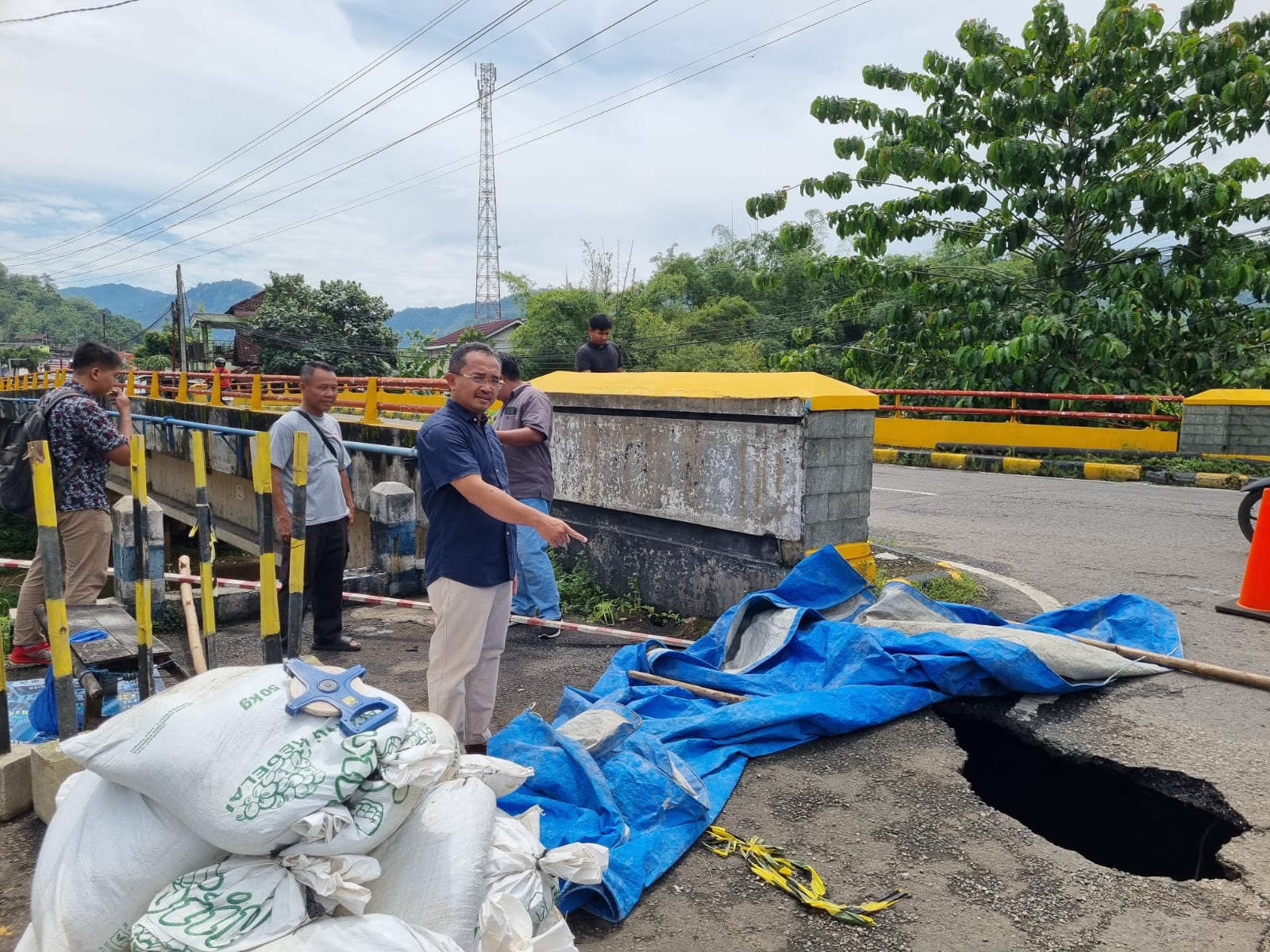 BERBAHAYA: Petugas dari pihak terkait melakukan pengecekan di lokasi aspal ambles di dekat Jembatan Arjosari, Pacitan, jalur utama Pacitan&ndash;Ponorogo. FOTO: NUR CAHYONO/RADAR PACITAN