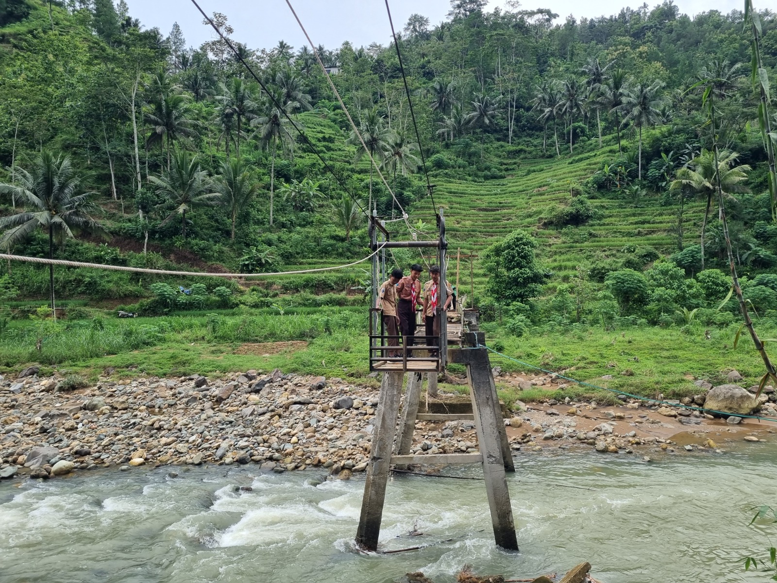 DARURAT: Warga Dusun Purworejo, Desa Gedangan, Ngrayun menyeberang Sungai Jabak memakai gondola karena jembatan rusak diterjang banjir. SUGENG DWI N/RADAR PONOROGO