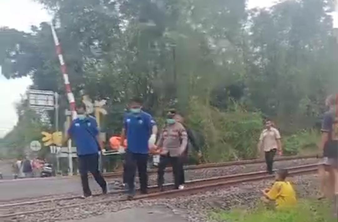 EVAKUASI: Petugas mengevakuasi jenazah korban yang ditemukan tewas tertabrak kereta api di jalur rel dekat perlintasan Desa Tambakromo, Geneng, Ngawi. FOTO: TANGKAPAN LAYAR