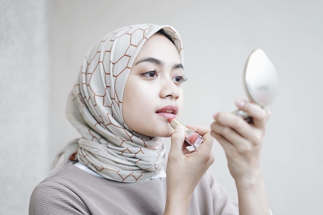 Ilustrasi perempuan memakai lipstik saat puasa.