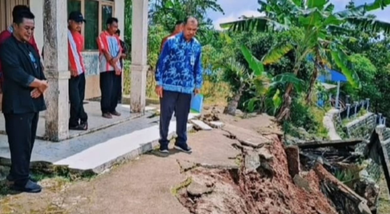 CEK LOKASI: Petugas Dindik Pacitan meninjau lokasi talud SDN 2 Kledung yang ambrol akibat hujan deras di Kecamatan Bandar. FOTO: ISTIMEWA