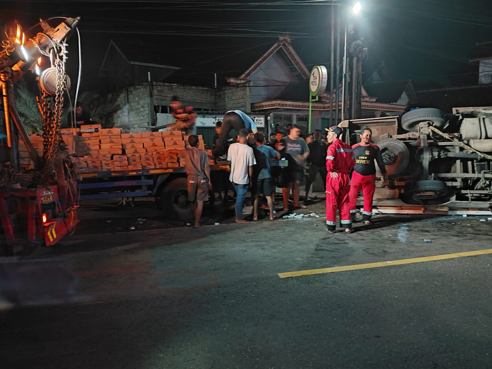 LAKA TUNGGAL: Truk pengangkut susu terguling di Jalan Raya Ponorogo&ndash;Trenggalek setelah mengalami ban pecah, warga membantu evakuasi muatan. DOK RADAR PONOROGO