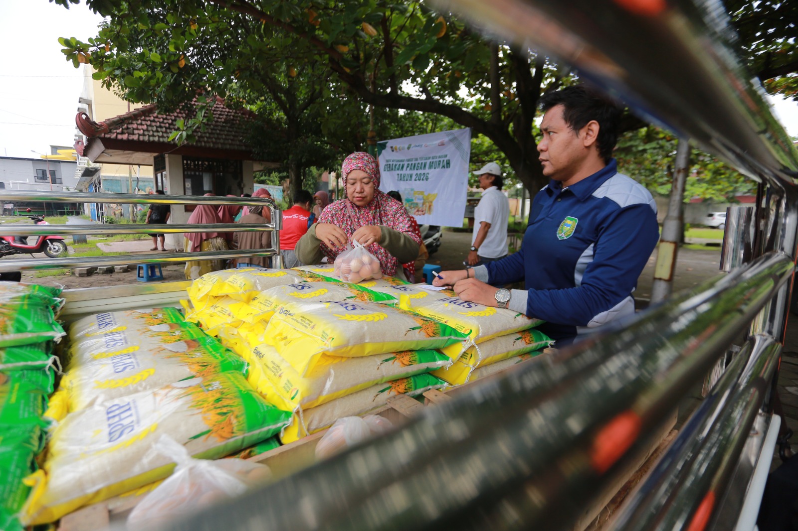 MURAH MERIAH: Warga mengantre membeli bahan pokok dalam Gerakan Pangan Murah di Dumilah Park. Sejumlah komoditas habis hanya dalam 1,5 jam, Selasa (24/2). BAGAS BIMANTARA/RADAR MADIUN