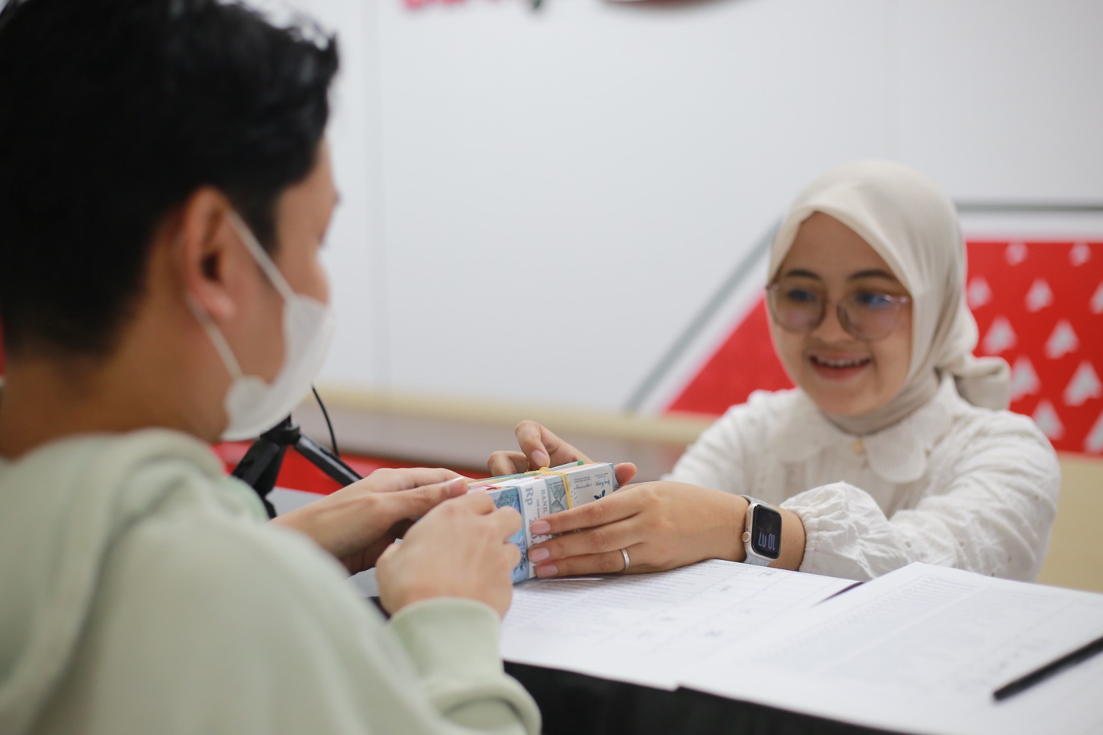 LAYANAN PENUKARAN: Warga menukarkan uang pecahan baru melalui layanan resmi Bank Indonesia di Bank Jatim Cabang Madiun untuk kebutuhan Lebaran. BAGAS BIMANTARA/RADAR MADIUN