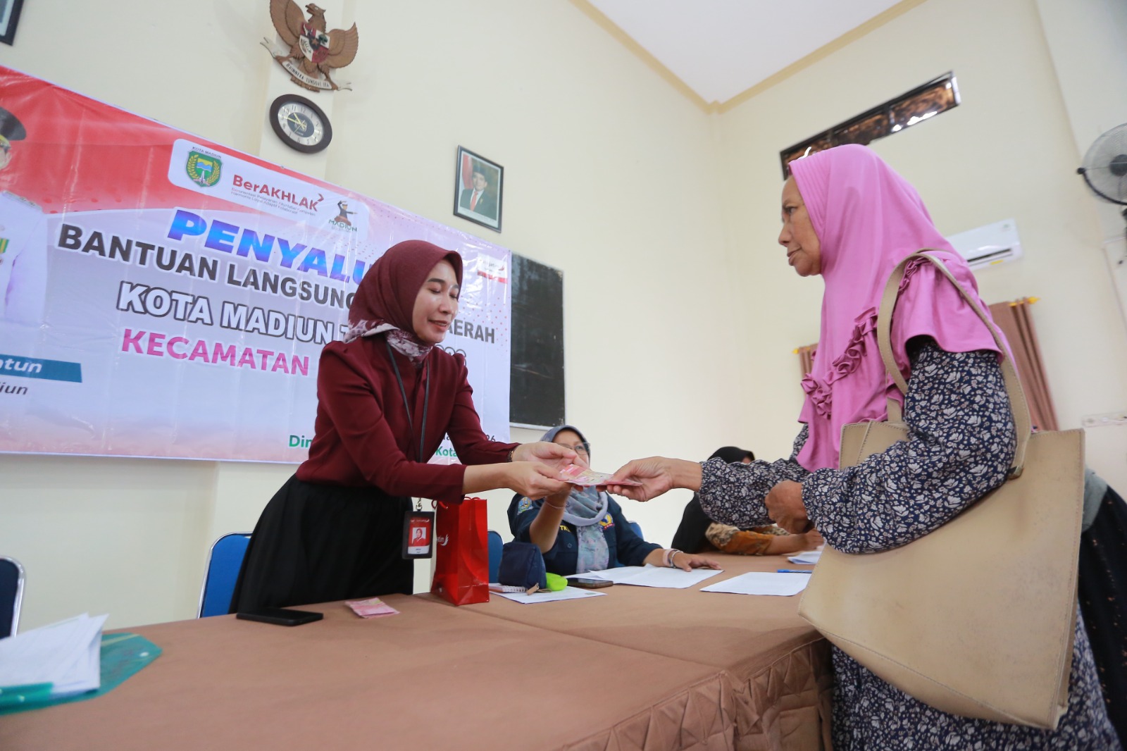 BANSOS: Warga menerima BLT DBHCHT sebesar Rp 200 ribu tahap pertama yang disalurkan Pemkot Madiun menjelang Ramadan. BAGAS BIMANTARA/RADAR MADIUN