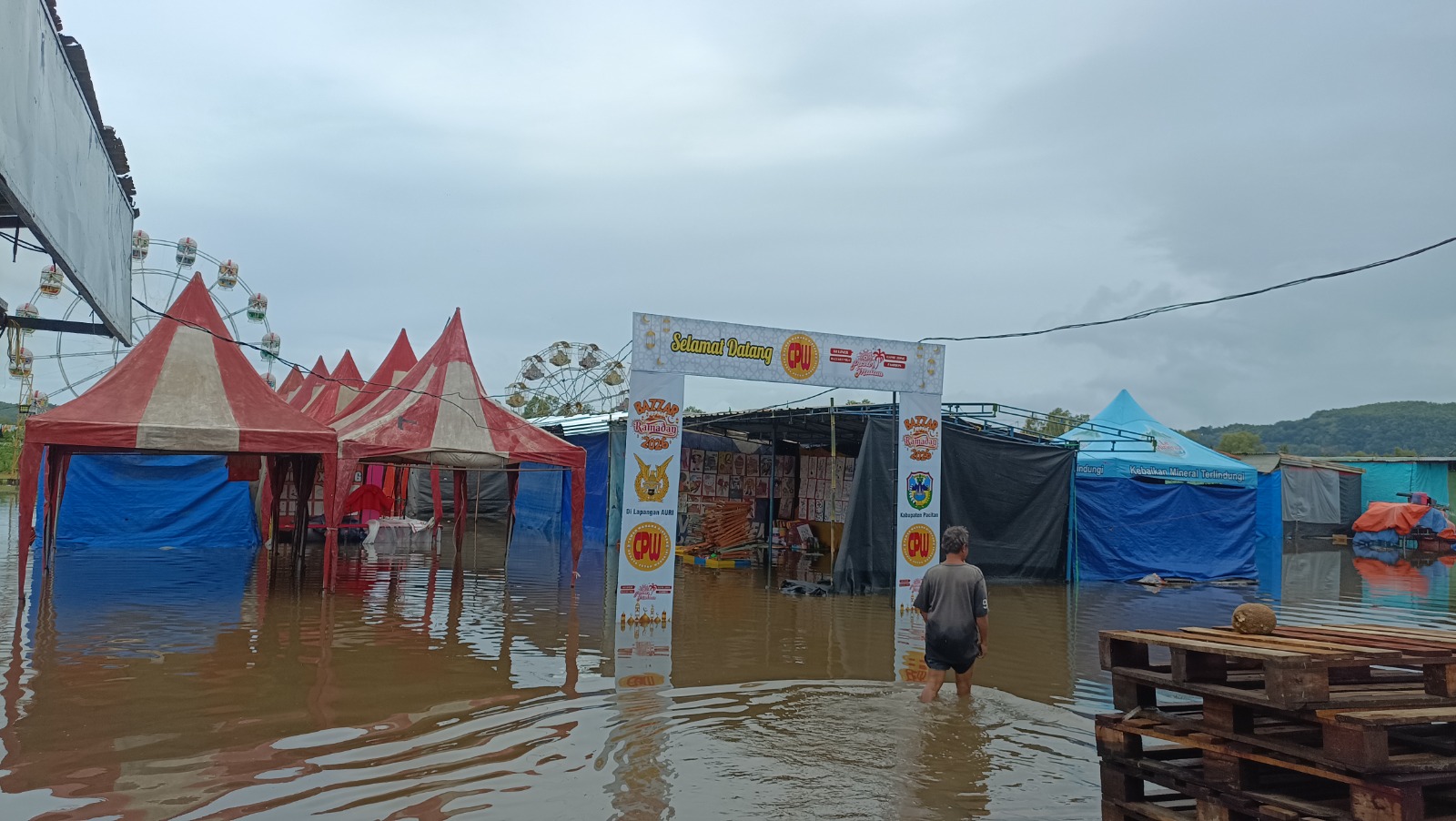 KEBANJIRAN: Genangan air merendam area Bazar Ramadan di Lapangan AURI Pacitan sehingga pedagang terpaksa menghentikan aktivitas jualan sementara. NUR CAHYONO/RADAR PACITAN