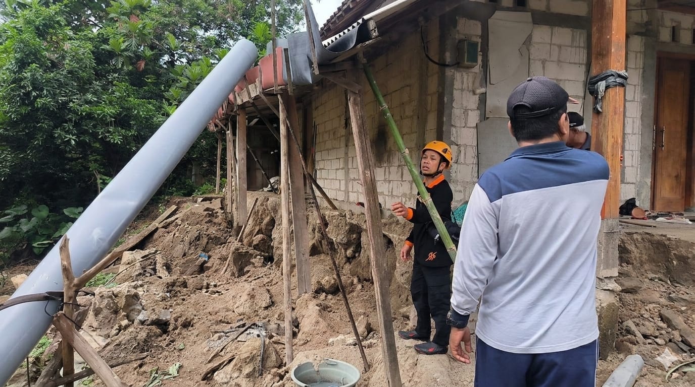 TERANCAM PUTUS: Retakan tanah di ruas jalan utama Desa Sumberbendo semakin melebar akibat pergerakan tanah yang kembali terjadi setelah hujan deras. FOTO: BPBD MADIUN