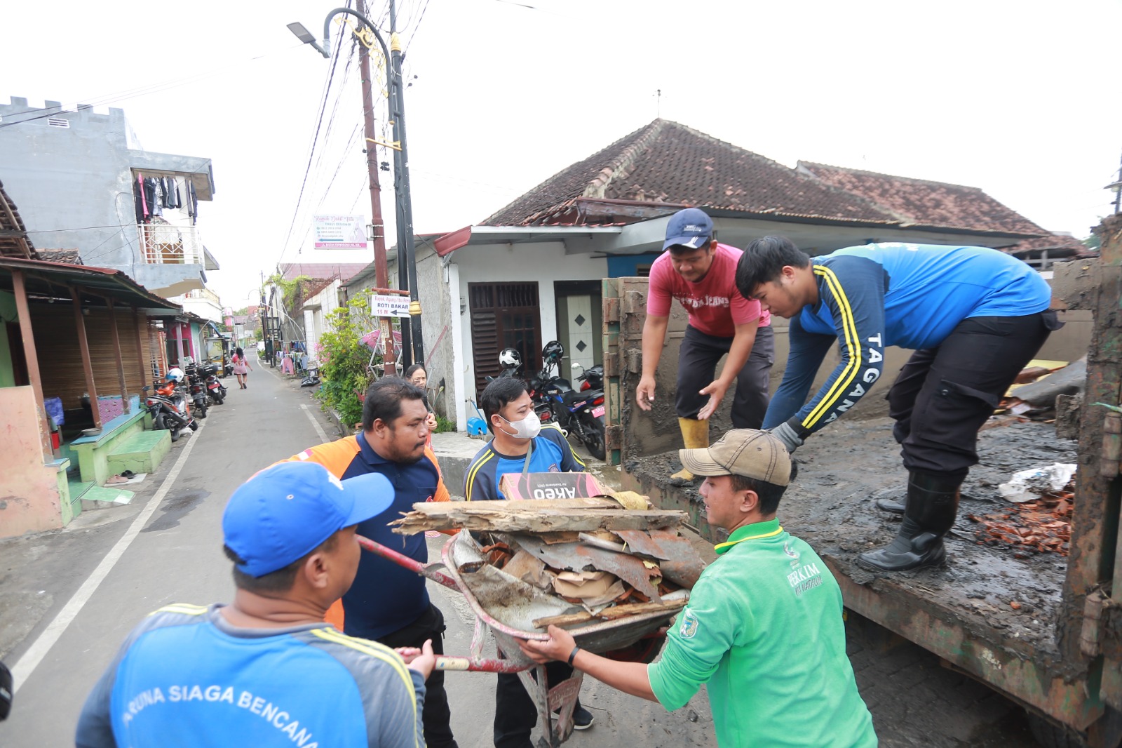 KERJA BAKTI: Petugas gabungan membersihkan material dan menurunkan sisa atap rumah roboh milik warga Kelurahan Manguharjo, Kota Madiun. BAGAS BIMANTARA/RADAR MADIUN