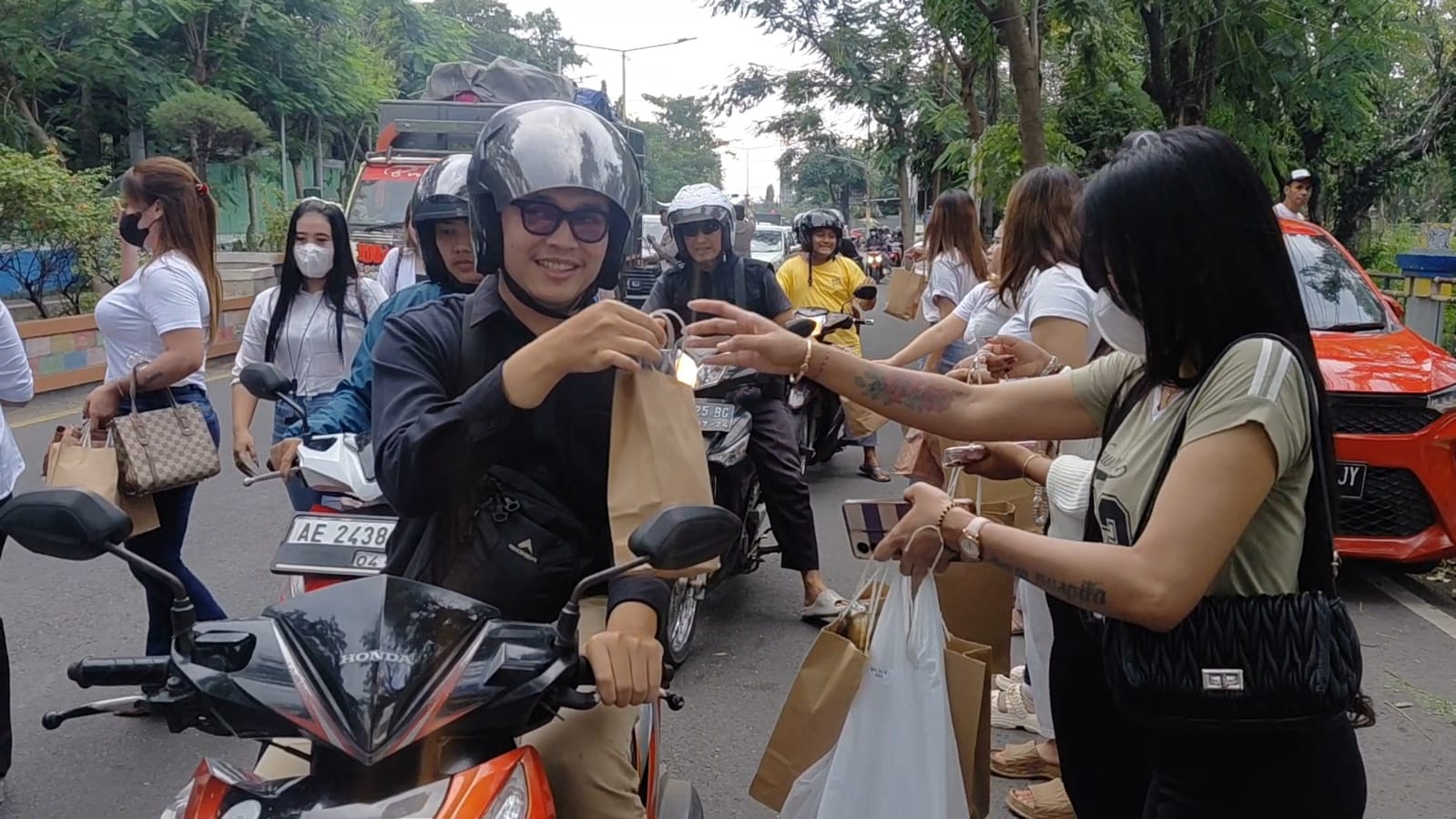 BERBAGI TAKJIL: Pemandu karaoke Radefa membagikan paket takjil kepada pengguna jalan di kawasan Terminal Purbaya Madiun. FOTO: ISTIMEWA