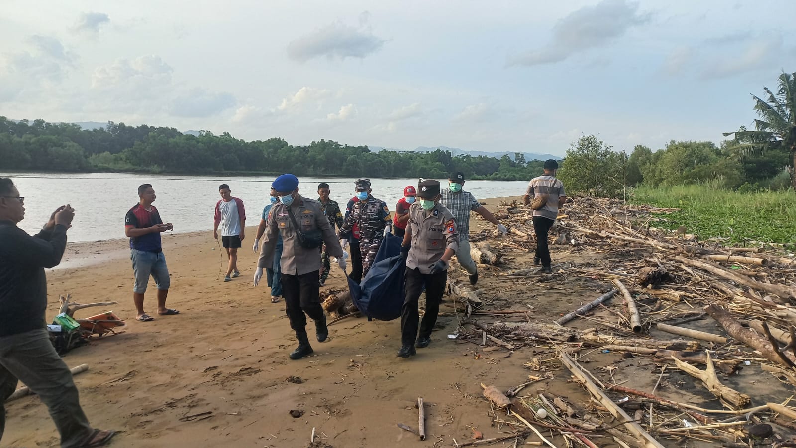 EVAKUASI JENAZAH: Petugas kepolisian mengevakuasi mayat pria tanpa identitas yang ditemukan di tepi Sungai Grindulu, Pacitan, Selasa sore. FOTO: ISTIMEWA