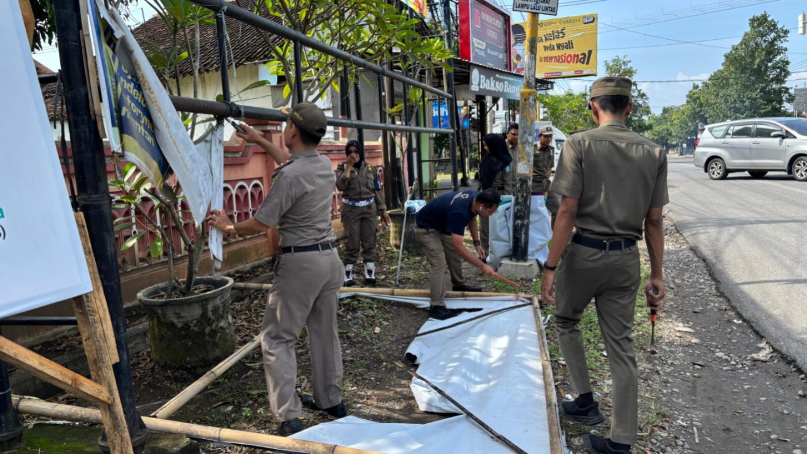 MERUSAK PEMANDANGAN: Satpol PP dan Damkar Ponorogo mencopot paksa baliho ilegal dan rusak di sejumlah ruas jalan, Selasa (10/3). FOTO: ISTIMEWA