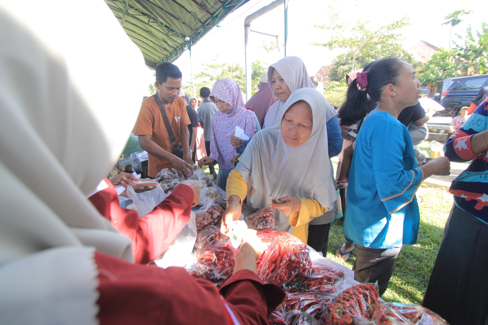 Warga mengantre membeli bahan pokok bersubsidi dalam kegiatan pasar murah di Lapangan Karangrejo, Kecamatan Kawedanan, Magetan. AJI PUTRA/RADAR MAGETAN