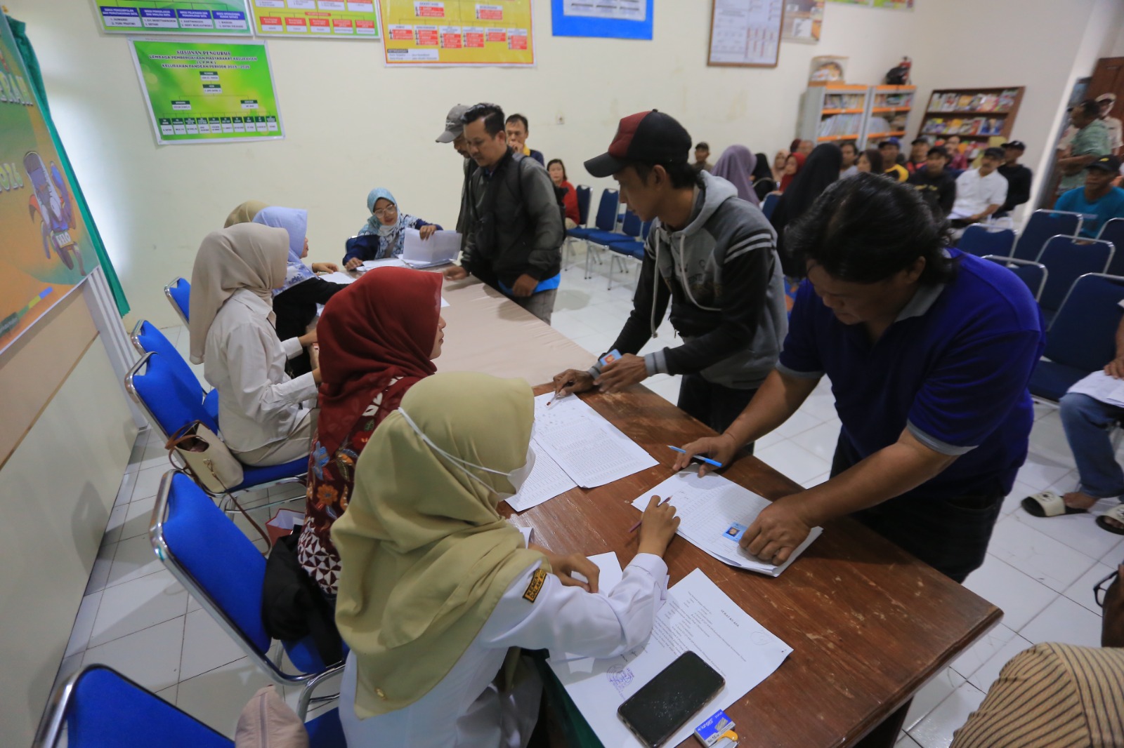 Warga antre mencairkan Bantuan Langsung Tunai Daerah (BLTD) tahap pertama di Aula Kelurahan Pandean, Kota Madiun. FOTO: BAGAS BIMANTARA/RADAR MADIUN