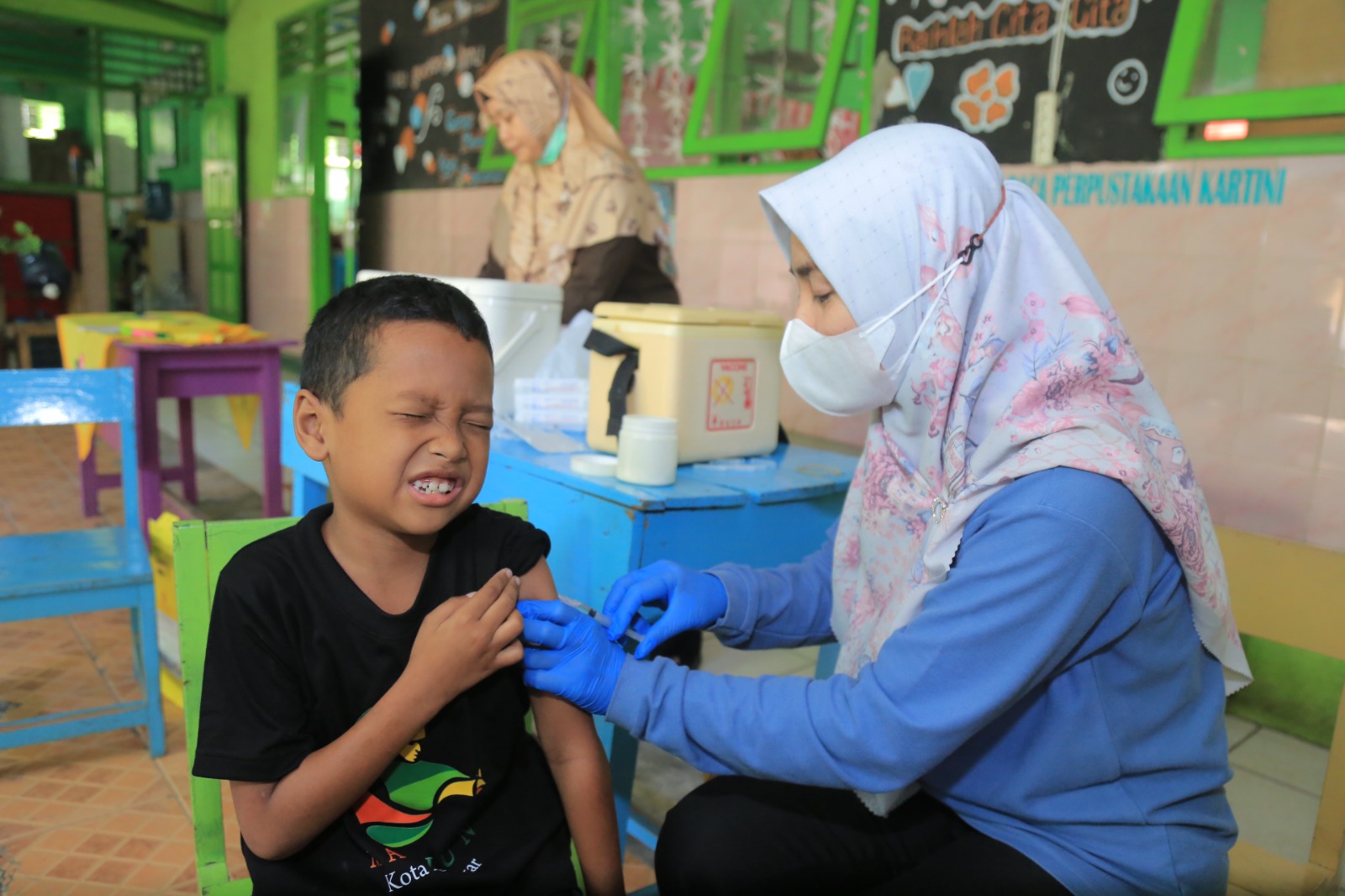 Petugas kesehatan melakukan imunisasi MR kepada anak sebagai upaya mencegah penyebaran penyakit campak di Kota Madiun. BAGAS BIMANTARA/RADAR MADIUN