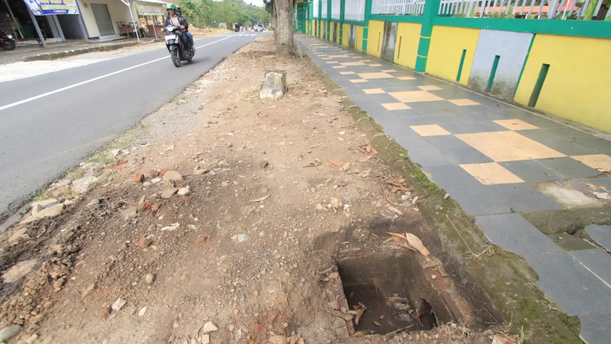 Kondisi drainase tanpa penutup di depan SMPN Ngariboyo, Magetan, yang berpotensi membahayakan pengguna jalan setelah besinya hilang dicuri. AJI PUTRA/RADAR MAGETAN
