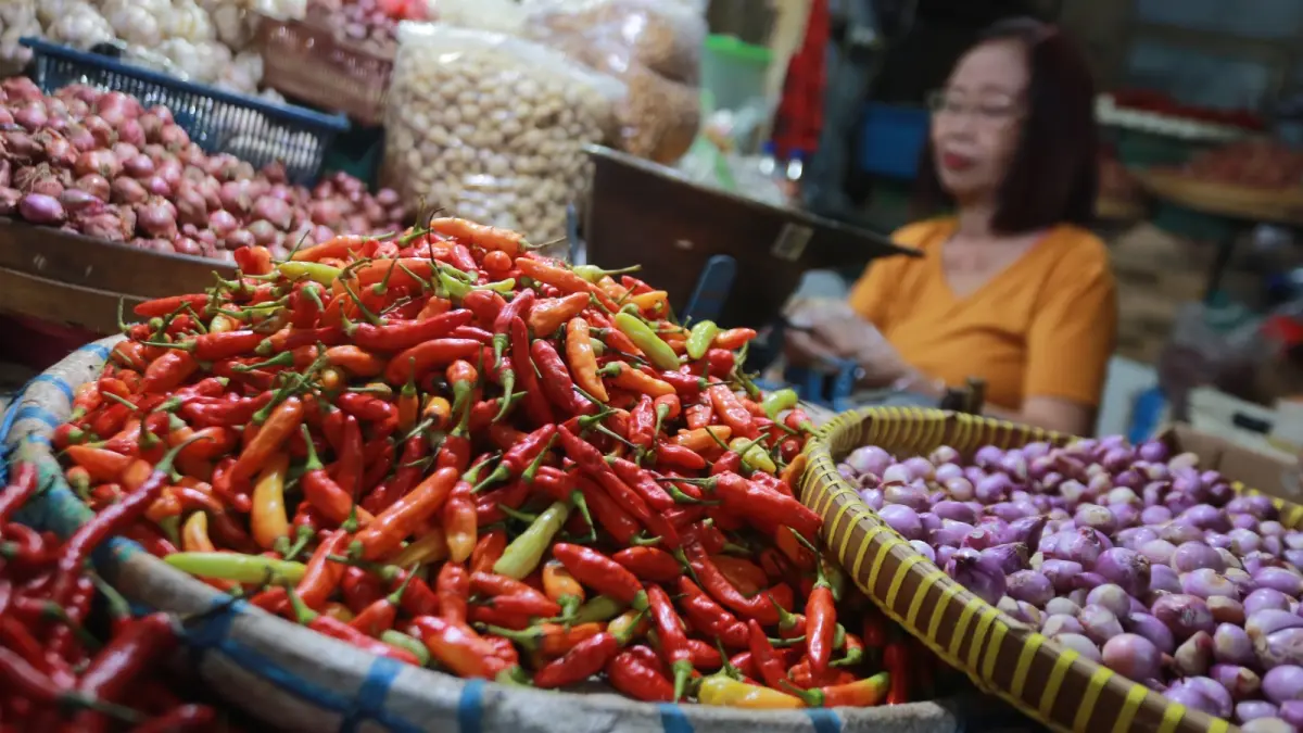 Pedagang melayani pembeli di Pasar Besar Madiun di tengah harga cabai rawit yang masih tinggi meski mulai turun. BAGAS BIMANTARA/RADAR MADIUN