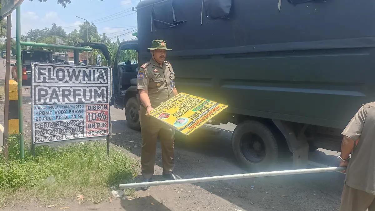 Petugas Satpol PP menertibkan reklame liar yang melanggar aturan di sejumlah titik Kabupaten Madiun. FOTO: SATPOL PP MADIUN