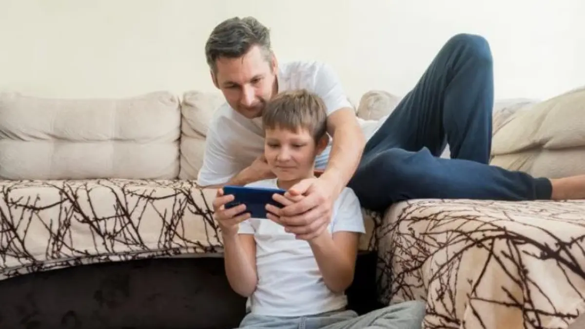 Ilustrasi orang tua mendampingi anak main game HP. (freepik)