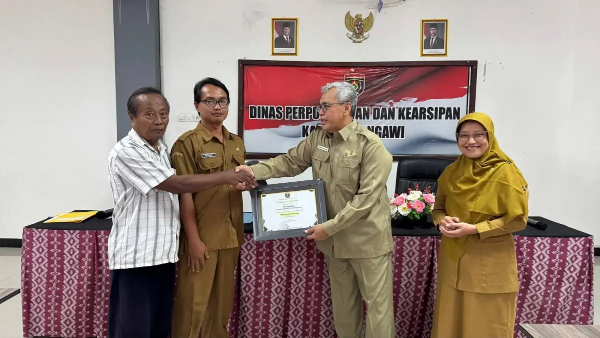 Kepala BKPSDM Ngawi sekaligus PLT Kepala Disperpusip Ngawi
menyerahkan piagam pemilik naskah kuno di akhir masa tugasnya Selasa (31/3) lalu. DOK RADAR NGAWI